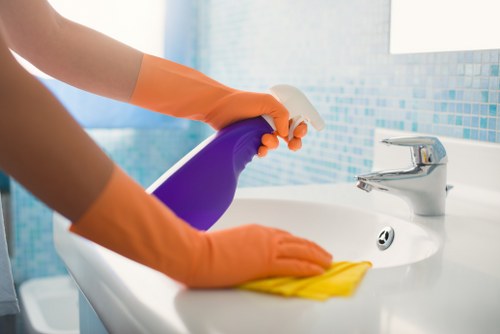 Professional cleaner following safe chemical handling procedures