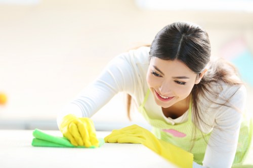 Cleaner wearing protective gloves while using approved cleaning products